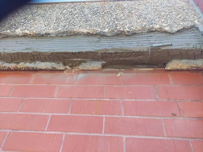 Repair mortar built up in keyed layers over the treated reinforcement