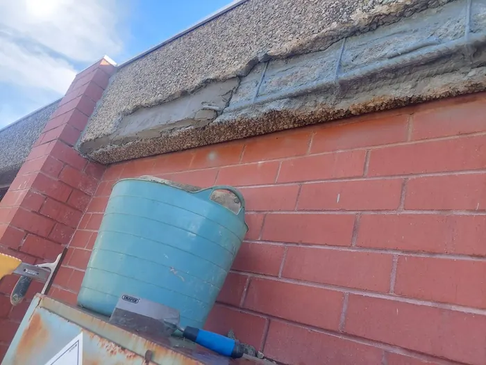 Concrete beam part way through the repair, with treated steel and the first repair mortar