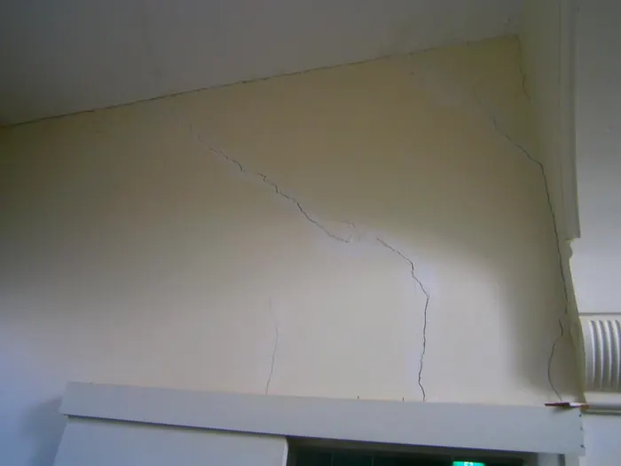 Diagonal plaster crack running from a door frame