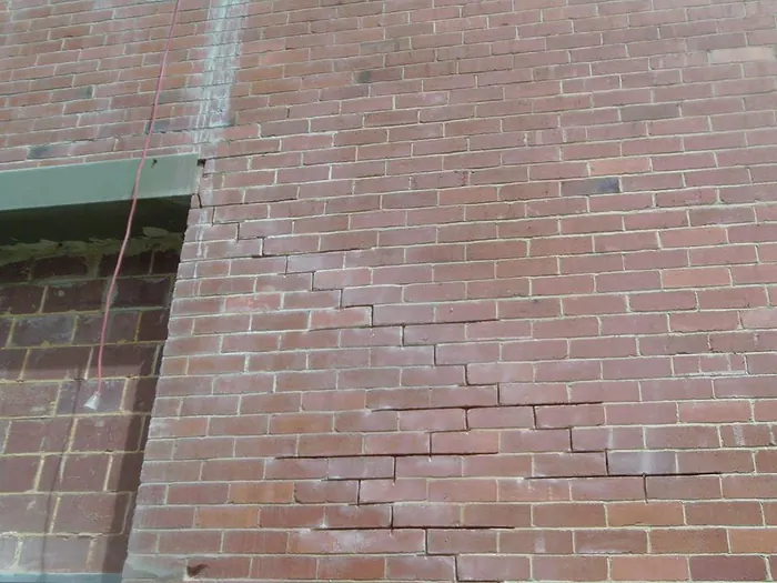 Severe stair-step crack in red brickwork before repair