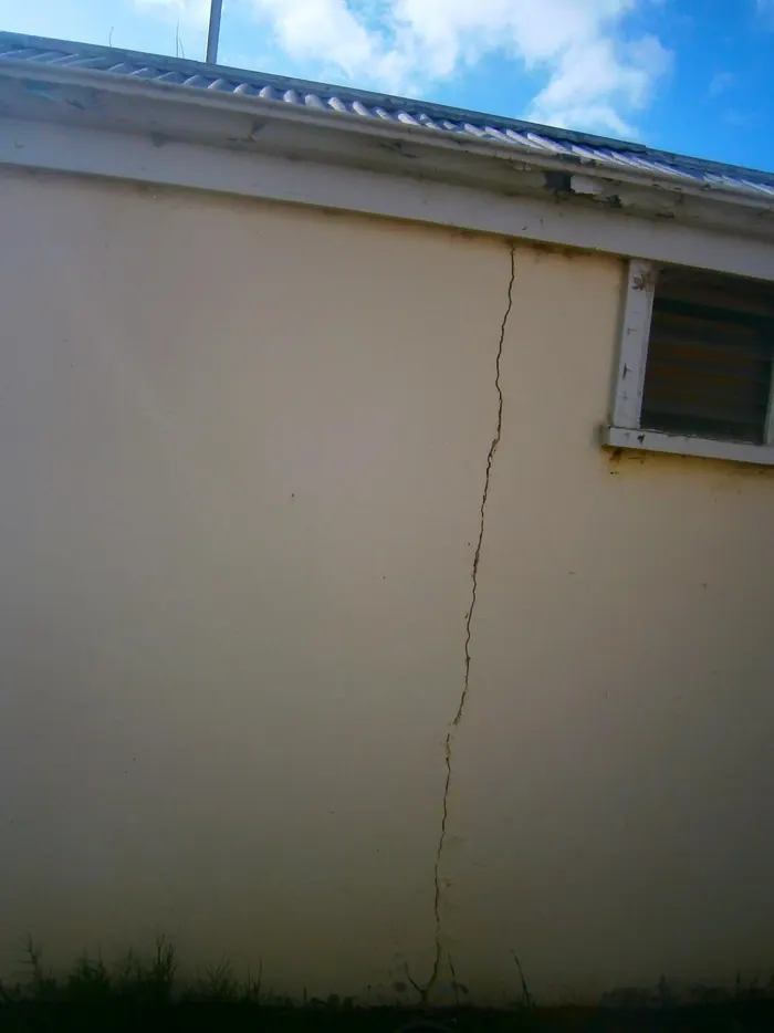 Vertical crack through a rendered wall before repair